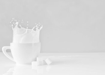 sugar block dropped on white cup with milk